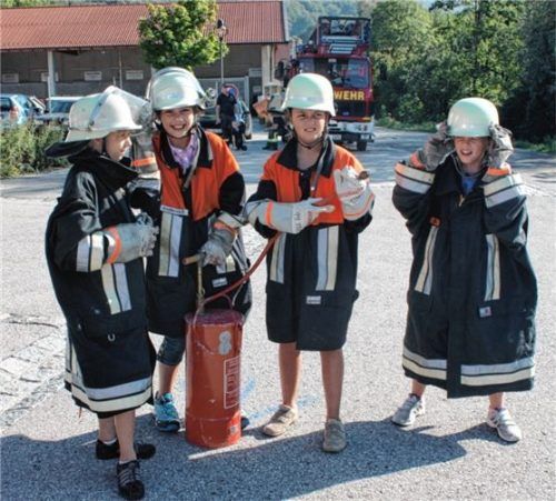 Einfach aber wirkungsvoll: Vier Nachwuchsfeuerwehrler probieren sich an der etwas älteren Kübelspritze. Fotos Rehberg