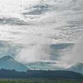 Berge sind in herbstlichen Nebel gehüllt
