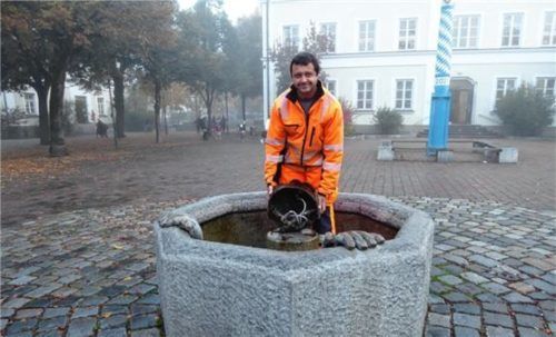 Christian Horn vom Bauhof bereitet den letzten der vier Kolbermoorer Brunnen für die kalte Jahreszeit vor. Foto  Riediger