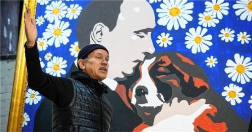 Der russische Künstler Alexey Sergienko gestikuliert neben seinem Gemälde „Putin mit einem Welpen“. Foto dpa