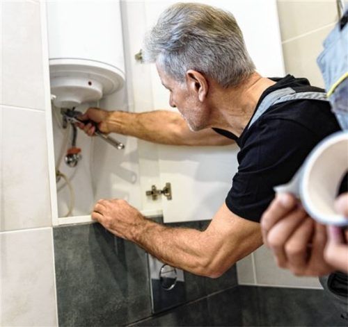 Installateur bei einer Reparatur. Foto Adobestock