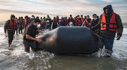 Migranten ziehen ein Schlauchboot aus dem Wasser am Strand von Gravelines. Seit Anfang des Jahres haben bereits mehr als 33500 Menschen die gefährliche Überquerung des Ärmelkanals geschafft.Foto dpa