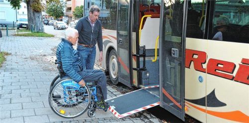 Teamarbeit: Harald Oberrenner, der Behindertenbeauftragte von Stephanskirchen, und Busunternehmer Gerhard Reiter versuchen gemeinsam, Oberrenner in den Bus zu bekommen. Denn alleine schafft der Rollifahrer es nicht. Foto SChlecker