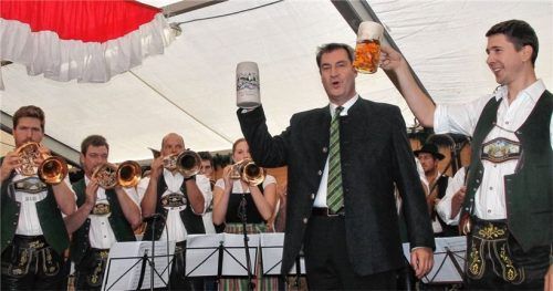 Unterstützt von einem kräftigen Tusch der Musikkapelle Bad Feilnbach unter der Leitung von Stefan Kirchberger (rechts) stößt Landesvater Markus Söder auf den Bad Feilnbacher Apfelmarkt an.