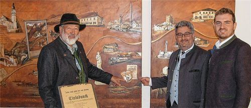 Beweis einer langen Tradition: Ehrenpräsident Georg Krapfl (links), der amtierende Präsident der Faschingsgesellschaft Flintsbach-Fischbach Franz Astner junior (rechts) und Bürgermeister Stephan Lederwascher bei der Übergabe der Faschingsschätze ins Flintsbacher Rathausarchiv. Foto RE