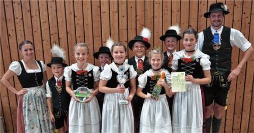 Die Siegergruppe der Kindergruppen 1 (bis zwölf Jahre) aus Ostermünchen mit Gaudirndlvertreterin Veronika Bauer (ganz links) und Zweitem Gauvorplattler Rupert Treml (rechts). Foto gaar