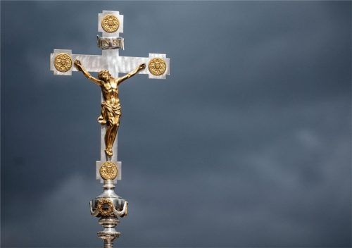 Ein Kruzifix ist beim Schlussgottesdienst des 102. Deutschen Katholikentags vor dunklen Wolken zu sehen. Foto dpa
