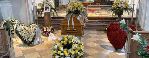 Heinz Winklers Sarg, umrahmt von Blumen, in der Aschauer Pfarrkirche.Fotos Schneider-Press/Frank Rollitz
