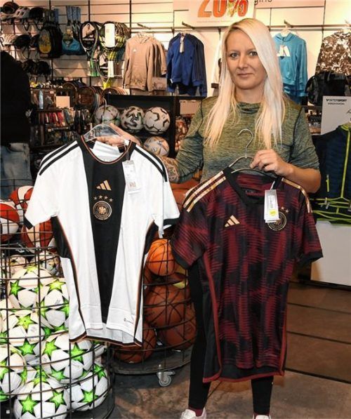 Verkäuferin Christin Roschek vom Intersport Siebzehnrübl in Rosenheim zeigt die DFB-Trikots. Foto Schlecker