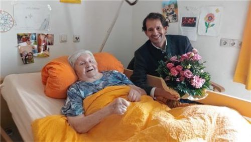 Bürgermeister Andreas März überreicht Magdalena Hergert einen Strauß Blumen. Foto Jennifer Beuerlein