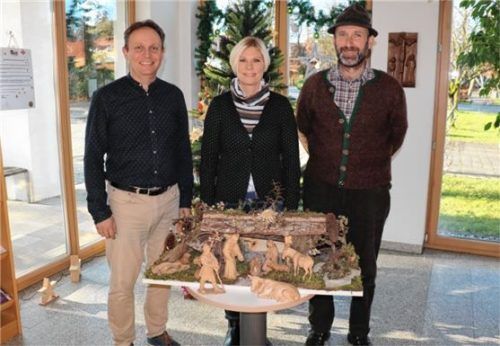 Bürgermeister Daniel Mair (links), die Leiterin der Tourist Info Frasdorf, Heike Stettner, und Peter Mayer mit der neuen Krippe im Frasdorfer Rathaus. Foto rehberg
