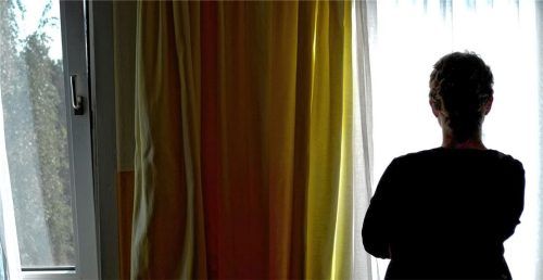 Eine junge Frau steht in einem Frauenhaus vor dem Fenster ihres Zimmers. Eigentlich könnte sie ausziehen, doch der Wohnungsmangel macht sich in vielen Einrichtungen bemerkbar – auch in Rosenheim. Foto  Steffen