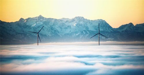 Zwei Windräder ragen am Morgen aus der Nebeldecke, während im Hintergrund durch den Föhn die über 100 Kilometer entfernten Alpen zu sehen sind. Foto dpa