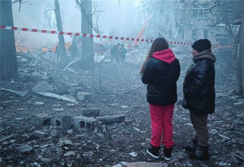 Anwohner stehen in der Nähe der Trümmer eines durch Beschuss zerstörten Einkaufszentrums. Foto dpa