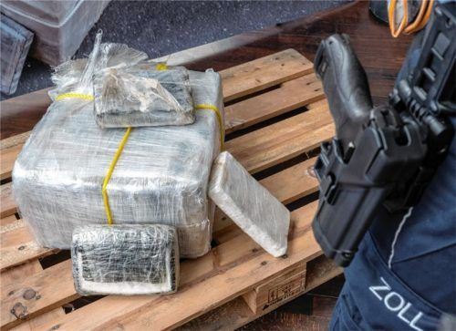 Ein Zollbeamter steht neben einem Päckchen von sichergestelltem Kokain. Foto dpa