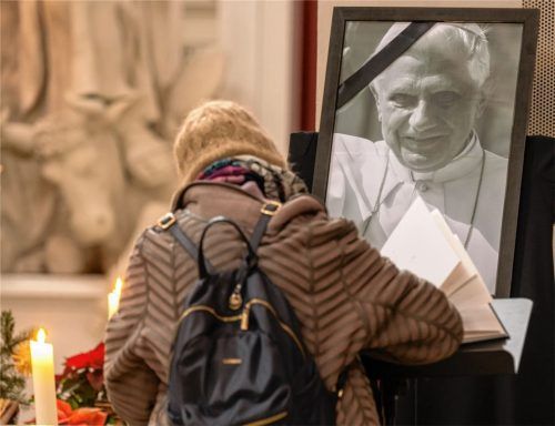 Eine Frau trägt sich in der Theatinerkirche in eine Kondolenzbuch für den verstorbenen emeritierten Papst ein. Benedikt XVI. ist am 31. Dezember 2022 im Alter von 95 Jahren in Rom gestorben. Foto dpa