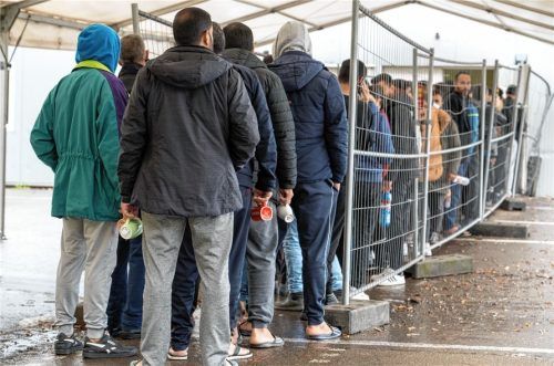 In der Landeserstaufnahmestelle warten Flüchtlinge in einer Schlange vor der Essensausgabe. Foto dpa