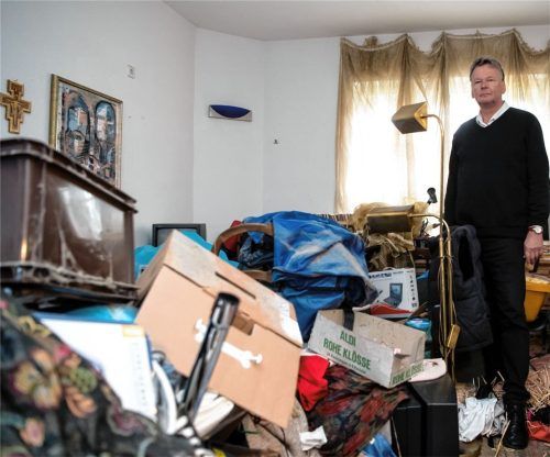 Michael Schröter vom Messie-Hilfe-Team steht mitten in einer zugemüllten Wohnung. Foto dpa
