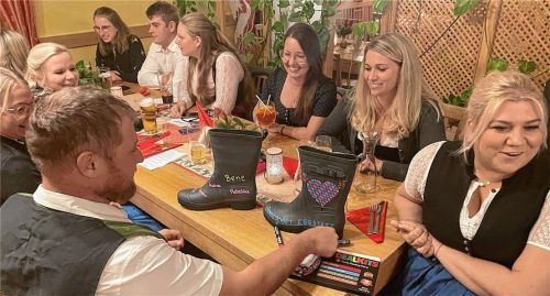 Ohne Unterschriften sind die Gummistiefel – das Geschenk für den Schirmherrn – nur halb so viel wert: Festleiter Bene Langl (links) kommt dem Charme der Eggstätter Dirndl nicht aus, und unterschreibt natürlich auch. Wie auch (von links) Isabella Weber, Sabrina Langl, Christina Plank, Marie Birner, Begleiter Michael Hamberger und Verena Ettenhuber. Foto Kirchner