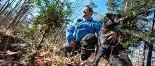 Rolf Müller, Fachbeauftragter des Nabu Baden-Württemberg für Jagd und Wildtiere, hockt mit seinem Hund in einem Waldstück bei Pforzheim neben einer verbissenen Weißtanne. Foto dpa