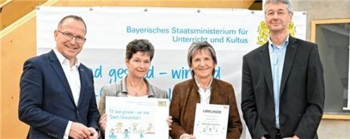 Kultusminister Dr. Michael Piazolo (rechts) und der Präsident des Bayerischen Landes-Sportverbands, Jörg Ammon (links), übergaben die Ehrung für die Schule an Schulleiterin Marianne Kelnberger (Zweite von rechts) und ihre Stellvertreterin Andrea Schirm. Foto Tobias Hase/StMUK