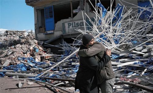 Zwei Männer umarmen sich inmitten von Trümmern. Mehr als eine Woche nach den verheerenden Beben in der Türkei und in Syrien ist die Hoffnung gering, noch weitere Überlebende unter den Trümmern zu finden. Foto dpa