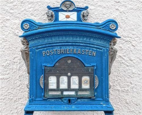 Der blaue Postbriefkasten gehört zu den Details, die auf die Vergangenheit des Gebäudes hinweisen.