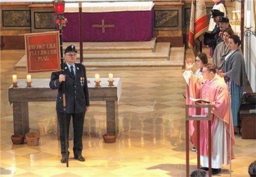 Ehrenmitglied Michael Paul (Mitte) erläutert die Bedeutung der historischen Fahne.Foto dAerzbäck