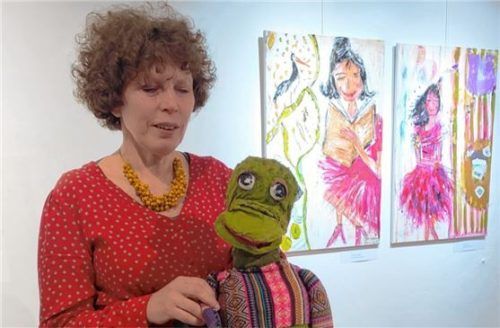 Michaela Schratzenstaller mit einer ihrer Puppen und verschiedenen Frauenbildern. Foto  Giesen