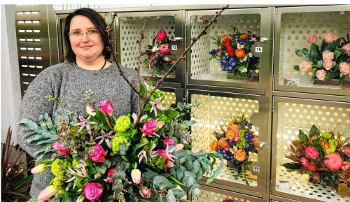Floristin Marion Schmid („Blumen Elsperger-Weiss“ in Kolbermoor) steht vor dem Blumenautomaten und freut sich auf einen Selbstbedienungsladen. Foto Bettinger