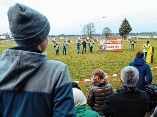 Gegner der geplanten Bahntrasse im Zuge der Baumaßnahmen zum Brenner-Nordzulauf stehen in Berg bei Ostermünchen mit Schildern auf dem Sportplatz, der der Strecke weichen müsste. Foto dpa