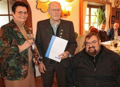 Lebenslange Treue: VdK-Ortsverband-Vorsitzende Ursula Danner (links) überreicht zusammen mit dem Kreisvorsitzenden Hans Loy (rechts) das VdK-Treueabzeichen für 70-jährige aktive Mitarbeit an Sebastian Bauer aus Frasdorf.Foto Rehberg