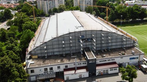 Aktuell wird im und um das Rosenheimer Eisstadion gebaut und saniert. Aber auch auf dem Dach tut sich etwas. Auf der linken Seite ist die neue Folie, die dringend nötig war,bereits so gut wie fertig verlegt. Rechts wird mit Hochdruck gearbeitet. Foto  Ziegler