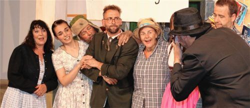 Foto für die Jubiläumsfeier in Niederhinterbergkirchenthalhausen: Gleisgeist Giacomo da Capo (Moritz Hecker) fotografiert (von links) Brunhilde (Gitti Pelzl), Mona (Marleen Graf), Weichen-Wastl (Wolfgang Grill), Bürgermeister Fritz Flitzmeier (Markus Aicher), die Schranken-Susi (Kathi Steiner), Ursel (Alexandra Frank) und den Standl-Hans (Florian Thalhammer).Foto  Rehberg