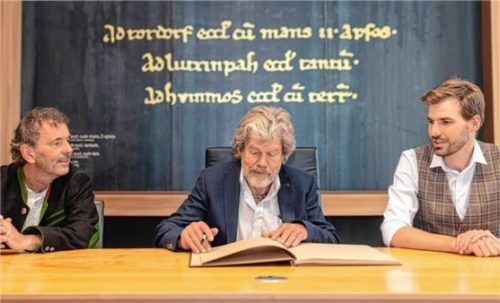 Reinhold Messner trägt sich ins Goldene Buch der Gemeinde ein, flankiert von Drittem Bürgermeister Martin Fischbacher und Bürgermeister Simon Hausstetter (rechts).Foto Thomae