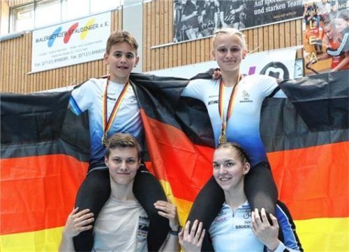 Stolze Goldmedaillengewinner und Deutsche Schülermeister im 2er-Kunstradsport der U15: Lisa und Benjamin Lechner von der Soli Bruckmühl. Lisa Lechner wird getragen von Trainerin Jana Pfann. Foto Wilfried Schwarz
