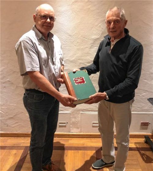 Altschatzmeister Dieter Vögele (rechts) überreicht anlässlich der Errichtung seines Ehrenamtes zur Dokumentation der Sektionsgeschichte sein umfangreiches Werk über die Sektion an den Sektionsvorsitzenden Josef Müller. Foto DAV-Sektion