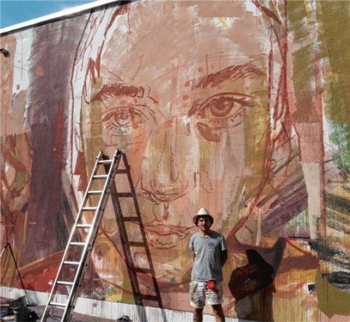 An eine Wand der Turnhalle der Lindgren-Grundschule hat Guido Palmadessa aus Buenos Aires eine Collage mit bunten Porträts gemalt.Foto Friedrich