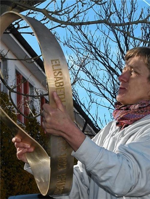 Bei der Arbeit: Die Künstlerin Christiane Huber bringt die Erinnerungsschleife an. Weitere sollen folgen. Foto Schlecker