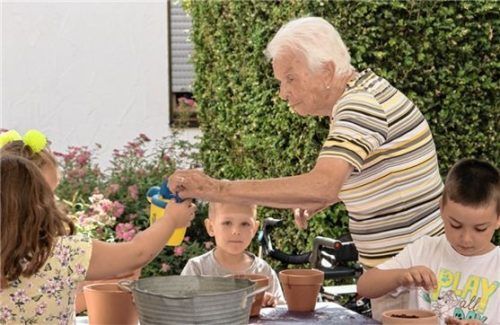 Der Samen ist gelegt: Kinder und eine Seniorin arbeiten am Blumentopf zusammen. Kennenlernen über Generationen hinweg klappt. Foto  Integrative Kindertagesstätte Katharina Bad Endorf