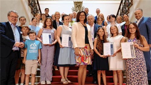In Vertretung der Schüler der Maria-Casper-Filser-Mittelschule Brannenburg nahm ihre Fachlehrerin Veronica Lax (Mitte links, in Blau) und die Geschäftsführerin des Flintsbacher Mehrgenerationenhauses für Demenzkranke Eva Faltner (zweite Reihe, schwarze Jacke) den Preis im Beisein (von links) des CSU-Landtagsabgeordneter Klaus Stöttner, der Präsidentin des Bayerischen Landtages Ilse Aigner, dem Lieutennant Governor von den Kiwanis Peter Bitzl und dem CSU-Landtagsabgeordneten Harald Kühn entgegen.Foto Kiwanis