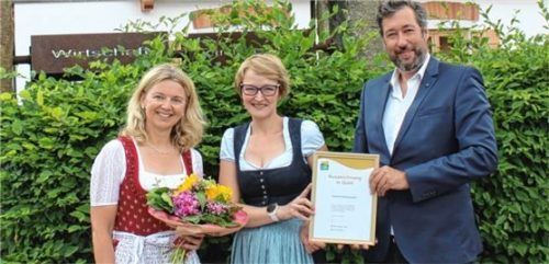 Oberaudorfs Bürgermeister Matthias Bernhardt (rechts) und Touristchefin Martina Schweinsteiger (links) überreichten der Wirtin vom Ochsenwirt Martina Knöckel die Urkunde. Foto Steffenhagen