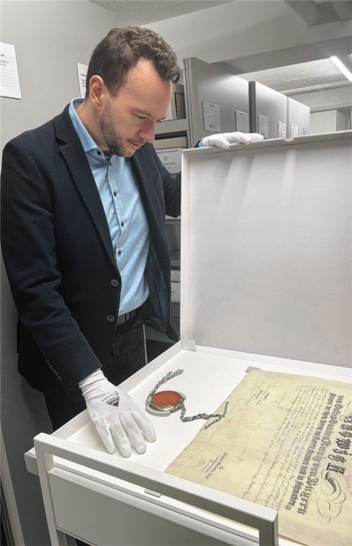 Von wegen verstaubt – für ihn ist es ein Traumjob: Christian Höschler ist der neue Leiter des Rosenheimer Stadtarchivs. Ein besonderes Schmankerl in seinem Haus ist die Stadterhebungsurkunde von König Ludwig II. Foto Stadt Rosenheim