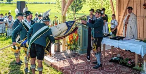 Bürgermeister Loferer bringt neue Fahnenbänder an.