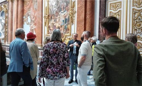 Der Historiker Marcus Spangenberg und die Teilnehmenden der Veranstaltung im Prunktreppenhaus von Schloss Herrenchiemsee. Foto Prien Marketing GmbH