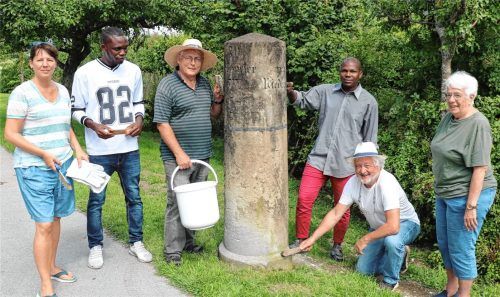 Die Vorsitzende des Aschauer Heimat- und Geschichtsvereins (HGV,) Dr. Natascha Mehler (links), und ihre freiwilligen Helfer am Kilometerstein in Hohenaschau.Foto Rehberg