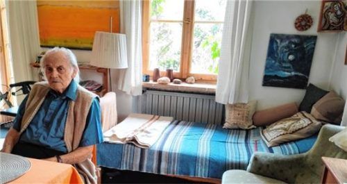 Hermann Wagner im Wohnzimmer seines selbst entworfenen Hauses in Seeon, umgeben von seinen Kunstwerken, zum Beispiel einer großformatigen gelb-orangen Bildmeditation und Madonnenbildern. Foto Giesen