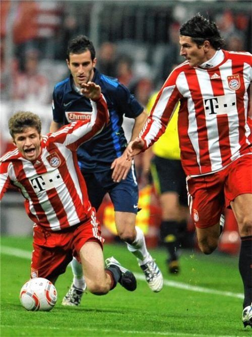 Im Trikot des SC Freiburg bringt Maxi Nicu Bayern-Star Thomas Müller zu Fall. Foto dpa/Tobias Hase