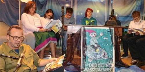Der kleine Wassermann (Philipp-Manuel Riedel, Mitte, mit roter Zipfelmütze), der Erzähler (Leopold Wimmer, vorne links) und die Figuren aus dem Mühlenteich bei der achten Otfried-Preußler-Gedächtnislesung im KIZ Aschau.