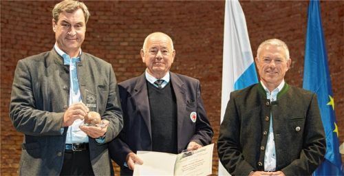 Ministerpräsident Dr. Markus Söder (links) und Thomas Lobensteiner, Landesleiter der Bergwacht Bayern (rechts), übergaben das Bergwacht-Edelweiß an Karl-Heinz Zeuner. Foto Bergwacht Bayern